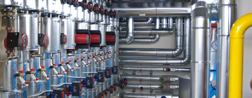 Industrielle Heizungsanlage mit isolierten Rohrleitungen, Speichern und gelber Gasleitung