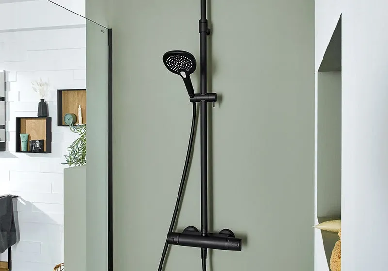 Schwarze Duschstange mit Handbrause und Thermostatarmatur vor salbeigrüner Wand