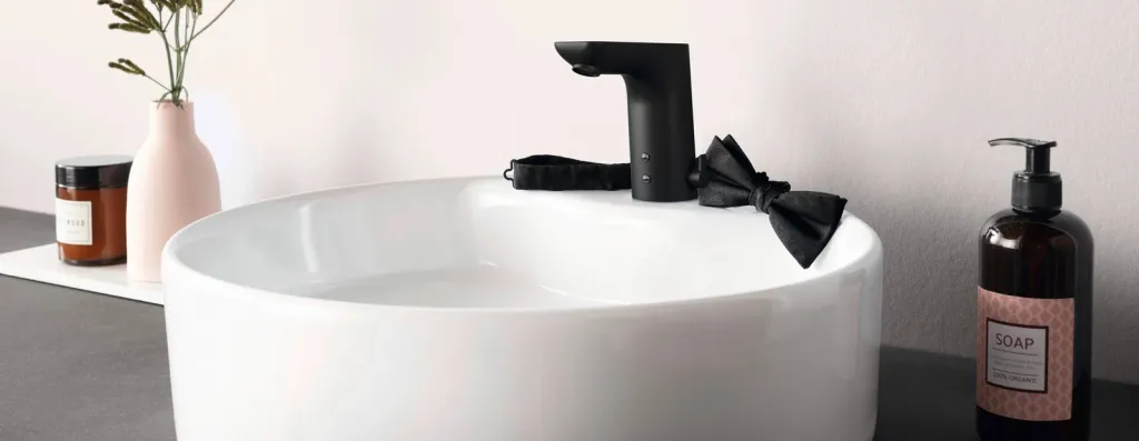 Rundes weißes Aufsatzwaschbecken mit schwarzer berührungsloser Waschtischarmatur