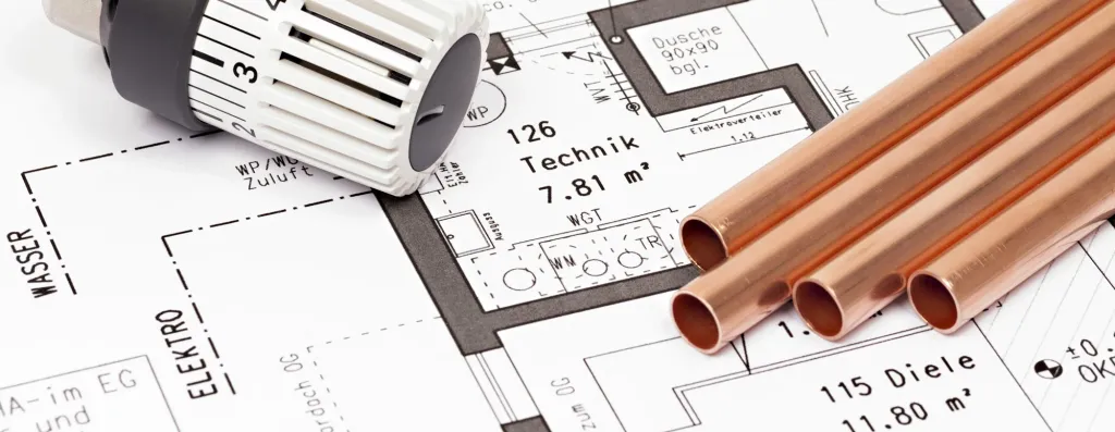 Thermostatventil und Kupferrohre auf einem technischen Bauplan für Hausinstallation