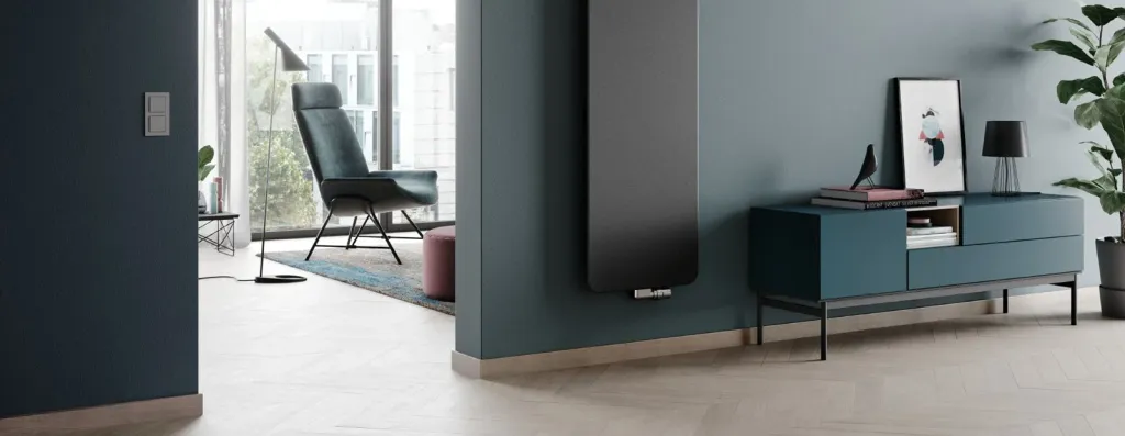 Modernes Wohnzimmer mit anthrazitfarbenem Flachheizkörper an blaugrauer Wand und Designermöbeln