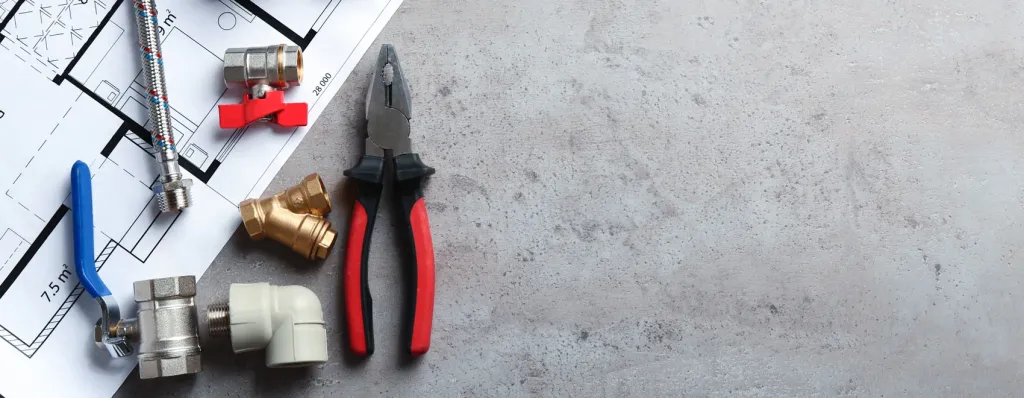Installateur-Werkzeuge mit Zange, Ventilen und Rohren auf technischem Bauplan